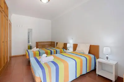 a bedroom with a green bed with two towels on it at Casa de férias a 75 metros da praia in Campo de Baixo