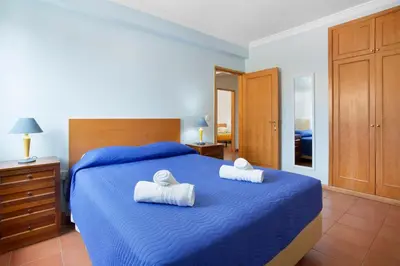 a bedroom with a blue bed with towels on it at Casa de férias a 75 metros da praia in Campo de Baixo