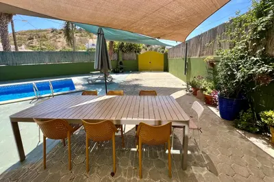 a wooden table with chairs and an umbrella on a patio at Country Villa work&relax in Lagos