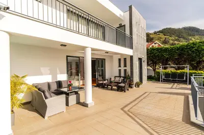 a patio with couches and chairs on a house at Villa Nunes, Big Holiday house with private pool in Calheta