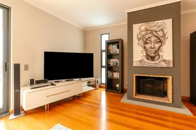 a living room with a television and a fireplace at Villa Nunes, Big Holiday house with private pool in Calheta