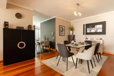 a dining room and living room with a table and chairs at Villa Nunes, Big Holiday house with private pool in Calheta