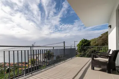 a balcony with a view of the water at Villa Nunes, Big Holiday house with private pool in Calheta
