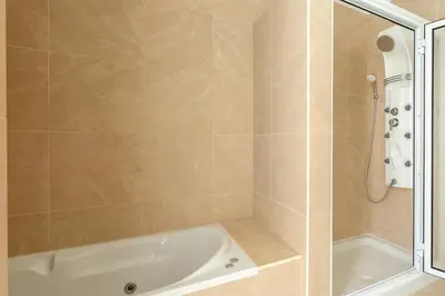 a bathroom with a shower and a bath tub at Villa Nunes, Big Holiday house with private pool in Calheta