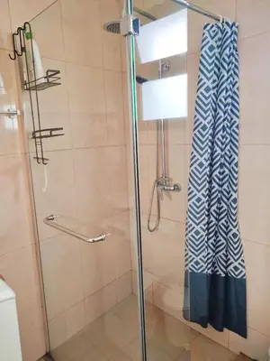 a bathroom with a shower with a glass door at A Casa Valentina - Estudio vista panorâmica para o mar in Estreito da Calheta