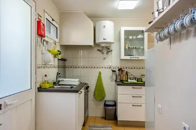 a small white kitchen with a sink and a refrigerator at Formosa Beach in Porto Santo