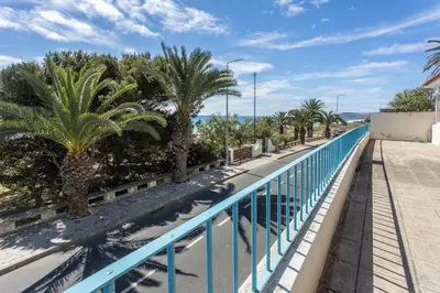 a balcony with palm trees and a blue railing at Formosa Beach in Porto Santo