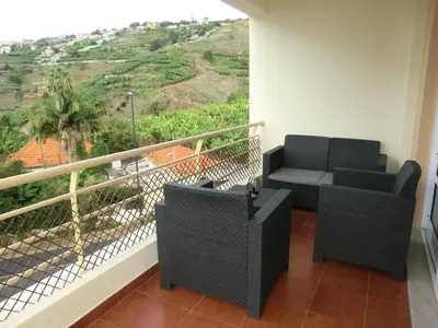 a balcony with two chairs and a table with a view at Formosa Sunset in Funchal