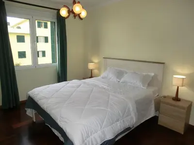 a bedroom with a large white bed with a window at Formosa Sunset in Funchal