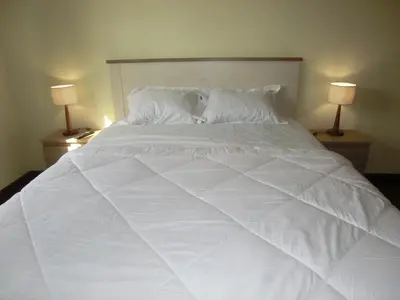 a large white bed with two lamps on two tables at Formosa Sunset in Funchal