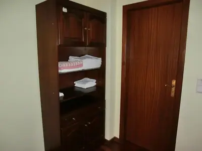 a closet with a wooden cabinet with towels in it at Formosa Sunset in Funchal