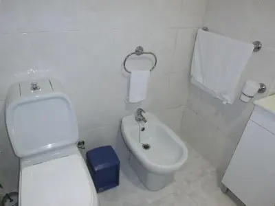 a white bathroom with a toilet and a bidet at Formosa Sunset in Funchal