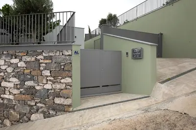 a building with a garage with a stone wall at King´s Paradise (Heated Pool and Sea View) in Estreito da Calheta