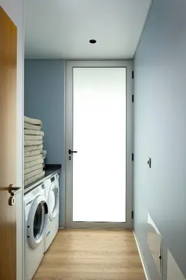 a laundry room with a washing machine and a door at King´s View (Heated Pool and Sea View) in Estreito da Calheta