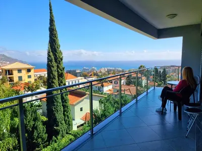 a view of a small town at sunset at Spacious Summer Fresh Family Apartment with Panoramic Sea Views in Funchal in Funchal