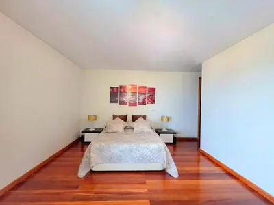 a white bedroom with a bed and two tables at Spacious Summer Fresh Family Apartment with Panoramic Sea Views in Funchal in Funchal