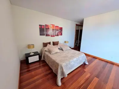 a bedroom with a bed and a wooden floor at Spacious Summer Fresh Family Apartment with Panoramic Sea Views in Funchal in Funchal