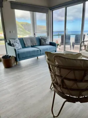 a living room with a blue couch and a chair at Casa de Praia in Almagreira