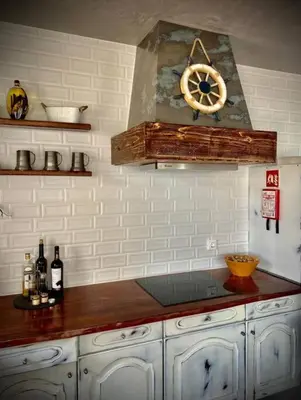 a kitchen with a counter with a clock on the wall at Casa de Praia in Almagreira