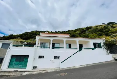 a white house with a hill in the background at Casa de Praia in Almagreira