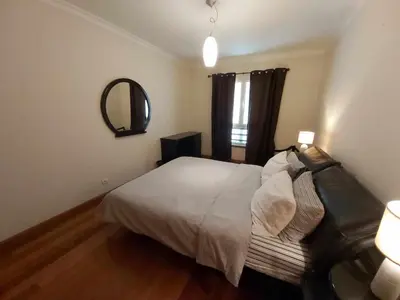 a bedroom with a bed and a mirror and a couch at Comfy and Charming Palace in Funchal