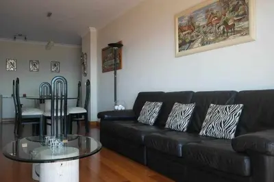 a living room with a black couch and a glass table at Comfy and Charming Palace in Funchal