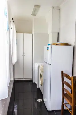 a kitchen with a refrigerator and a washer and dryer at Casa do Sol in Ponta do Sol
