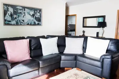 a black leather couch with three pillows on it at Casa do Sol in Ponta do Sol