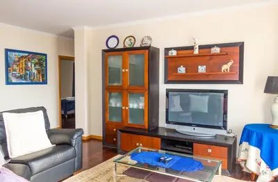 a living room with a couch and a television at Casa do Sol in Ponta do Sol
