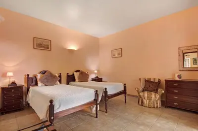 a bedroom with two beds and a chair at Casa Catarina in Santo da Serra