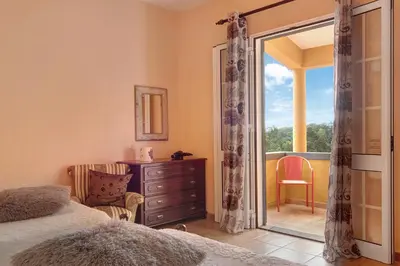 a bedroom with a door open to a balcony at Casa Catarina in Santo da Serra