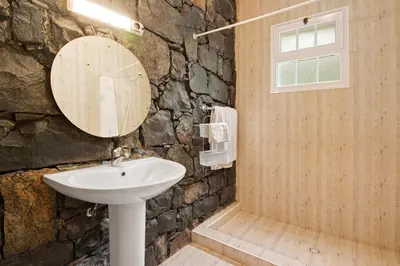 a stone bathroom with a sink and a mirror at Casa Catarina in Santo da Serra