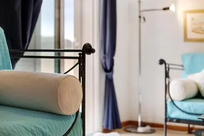 a room with a bed and a lamp and a chair at Apartamento A Quinta Porto Santo in Campo de Baixo