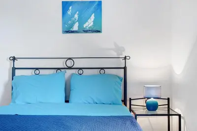 a bedroom with a blue bed and a lamp at Apartamento A Quinta Porto Santo in Campo de Baixo