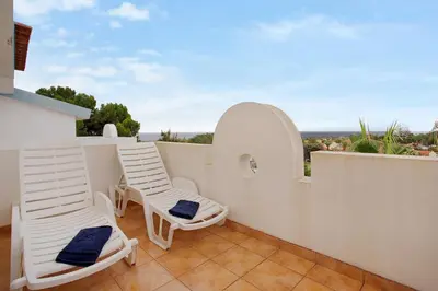a balcony with chairs and a view of the ocean at Apartamento A Quinta Porto Santo in Campo de Baixo