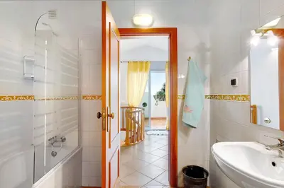 a white bathroom with a sink and a toilet at Apartamento A Quinta Porto Santo in Campo de Baixo