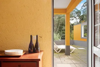 a glass door leading into a patio with two vases at Casa Cristina in Santo da Serra