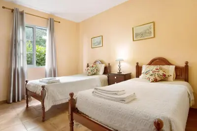 a bedroom with two beds and a window at Casa Cristina in Santo da Serra