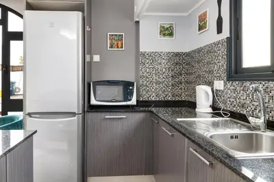 a kitchen with a refrigerator and a sink at Villa Garajau House in Caniço