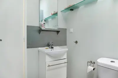 a white bathroom with a sink and a toilet at Villa Garajau House in Caniço