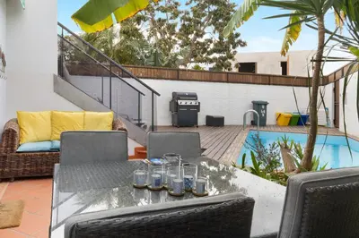 a patio with a table and chairs and a pool at Villa Garajau House in Caniço