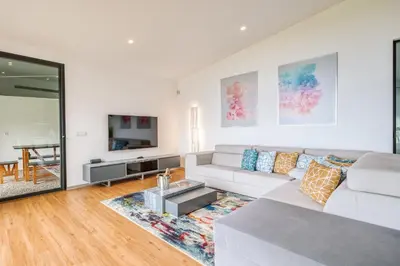 a living room with a white couch and a tv at Vila Aguarelas with pool by Stay Madeira Island in Arco da Calheta