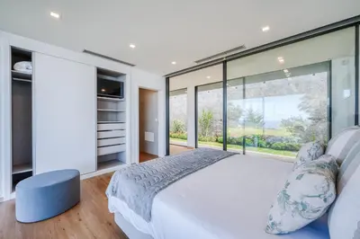 a bedroom with a large bed and a large window at Vila Aguarelas with pool by Stay Madeira Island in Arco da Calheta