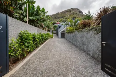 a path leading to a house with a mountain in the background at Vila Aguarelas with pool by Stay Madeira Island in Arco da Calheta