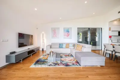 a living room with a white couch and a rug at Vila Aguarelas with pool by Stay Madeira Island in Arco da Calheta