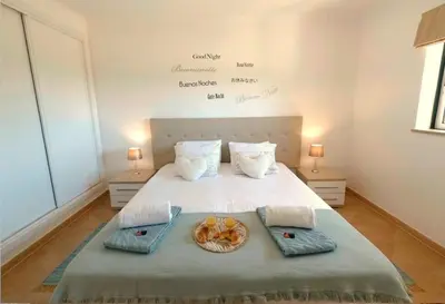a bed with two towels and a basket of food on it at Appartement Willy St. James Luz in Luz