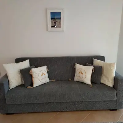 a gray couch with pillows on it in a room at Appartement Willy St. James Luz in Luz