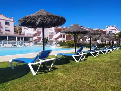 a row of chairs and umbrellas next to a pool at Appartement Willy St. James Luz in Luz