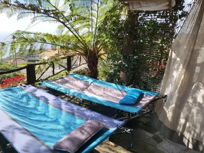 a hammock sitting on top of a balcony at Boutique Chalet in Calheta in Arco da Calheta