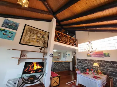 a living room with a fireplace and a table at Boutique Chalet in Calheta in Arco da Calheta